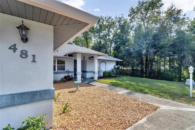 a front view of a house with a yard and trees