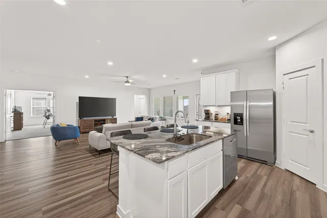 a large kitchen with a center island and stainless steel appliances