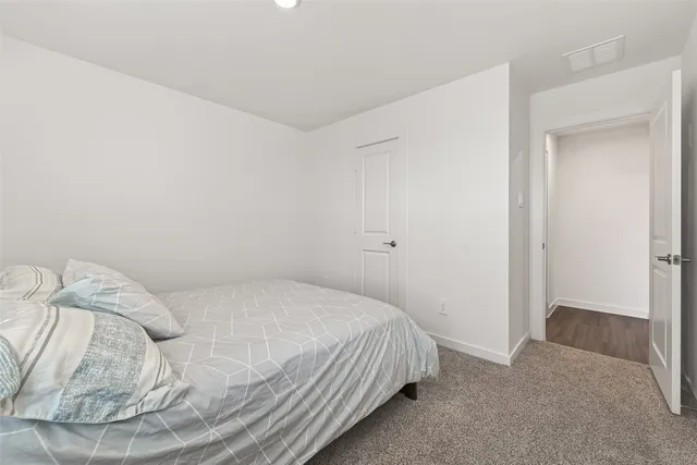 a bedroom with a bed and a flat tv screen on dresser