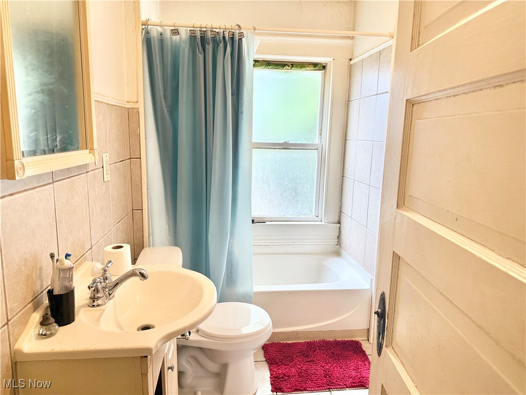 18211 Landseer Road Cleveland, OH 44119 - Photo 13 of 19 Full bath featuring healthy amount of natural light, tile walls, vanity, and shower / bath combo