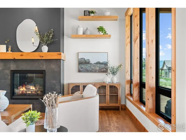 a living room with furniture a fireplace and a floor to ceiling window