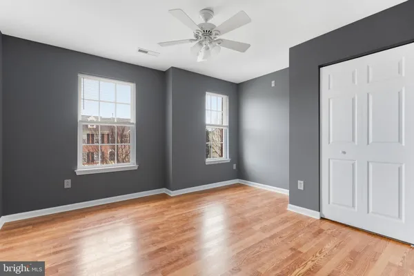 a view of an empty room with window and wooden floor