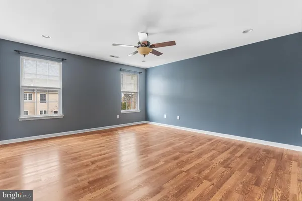 an empty room with windows and fan