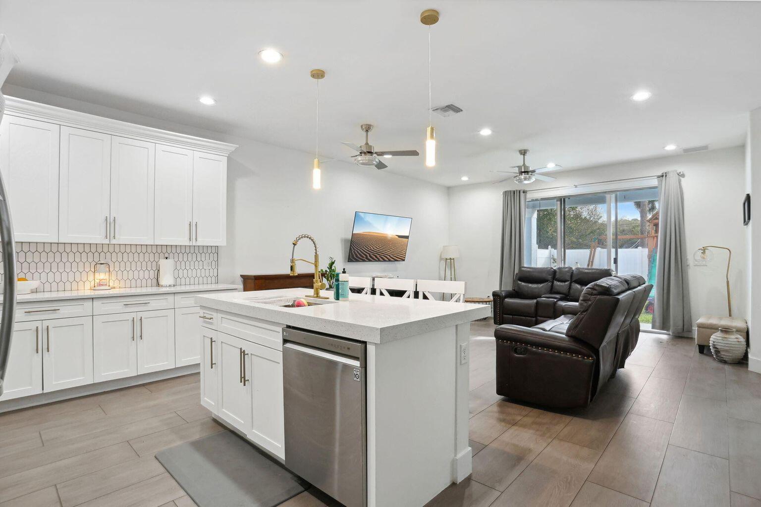 6944 2nd Street Jupiter, FL 33458 - Photo 2 of 26 a kitchen with a sink stove and cabinets