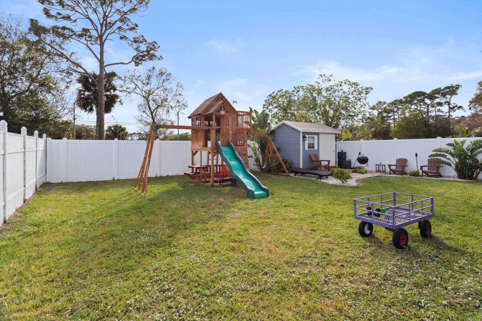 6944 2nd Street Jupiter, FL 33458 - Photo 26 of 26 a view of a house with a yard patio and fire pit