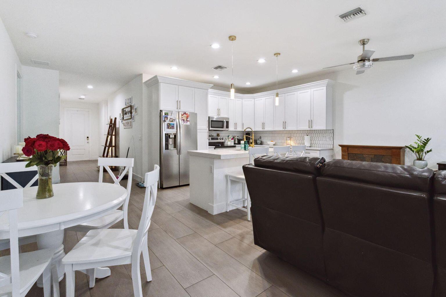 6944 2nd Street Jupiter, FL 33458 - Photo 5 of 26 a living room with stainless steel appliances kitchen island granite countertop furniture and a dining table