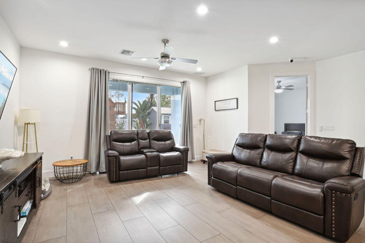 6944 2nd Street Jupiter, FL 33458 - Photo 6 of 26 a living room with furniture and a flat screen tv