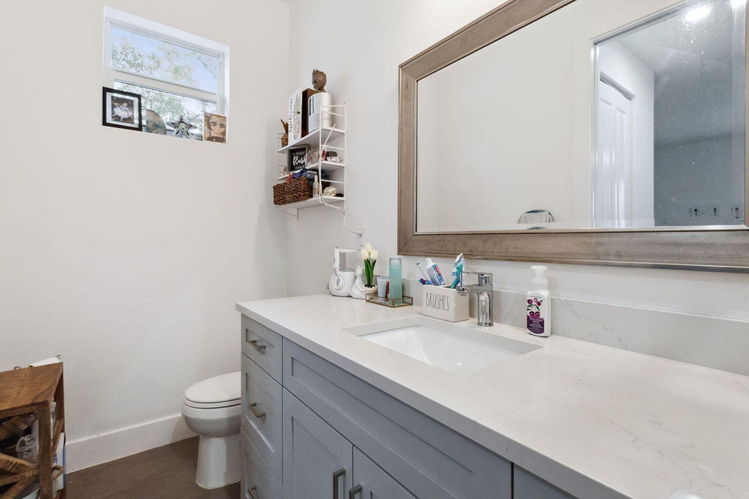6944 2nd Street Jupiter, FL 33458 - Photo 9 of 26 a bathroom with a sink vanity and a toilet