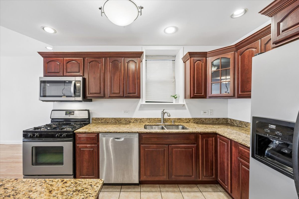 2363 East 70th Street, Unit 1 Chicago, IL 60649 - Photo 14 of 26 a kitchen with stainless steel appliances granite countertop a stove sink and cabinets