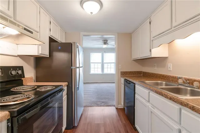 a kitchen with granite countertop a sink stove and refrigerator