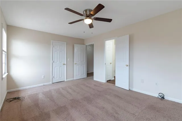 a view of an empty room and a ceiling fan