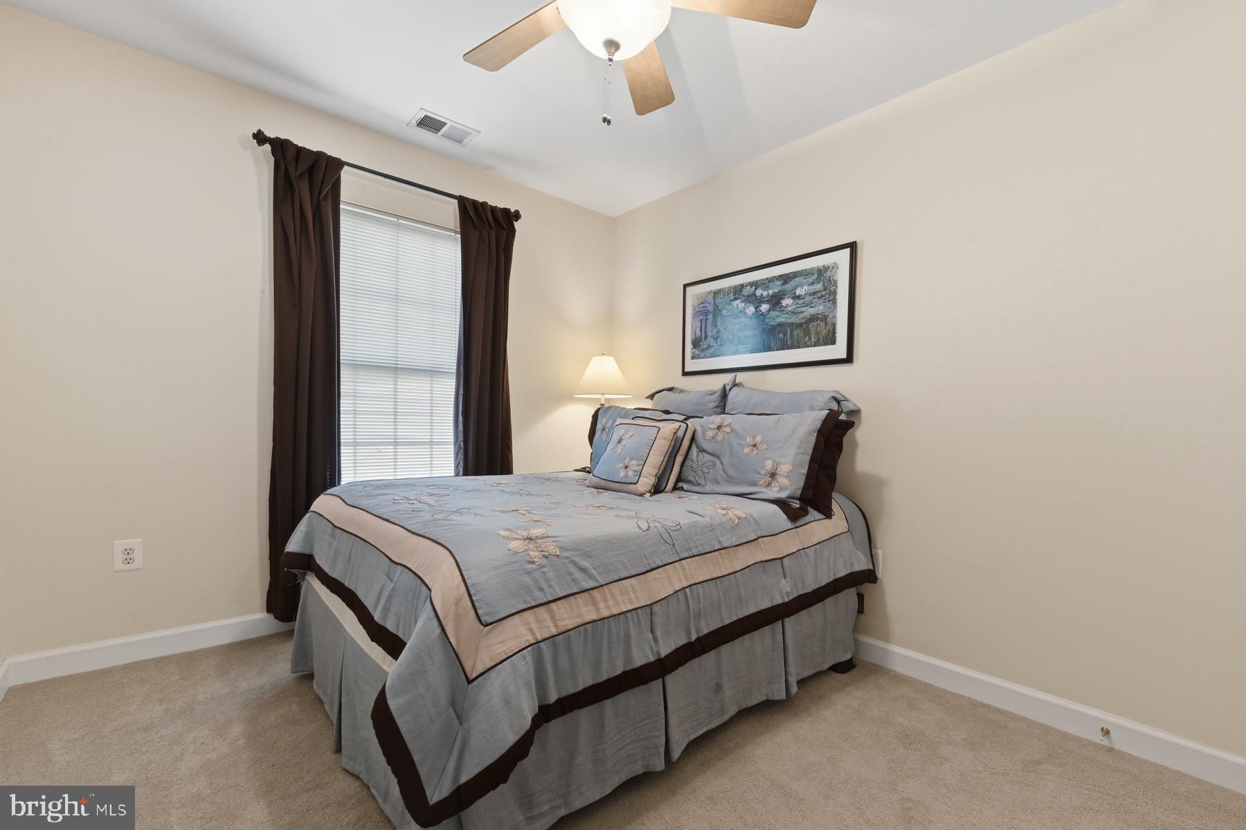 11206 Poplar Grove Court Laurel, MD 20708 - Photo 31 of 67 a bed sitting in a bedroom next to a window