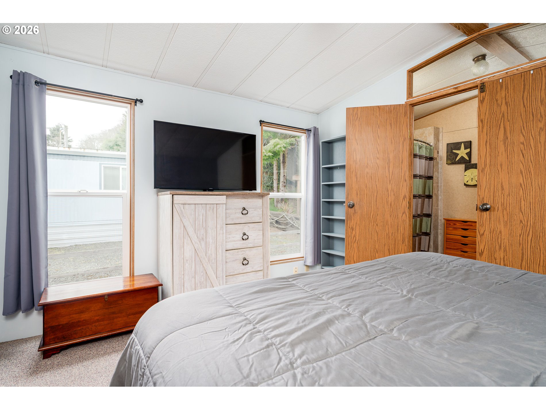 648 South Easy Street Rockaway Beach, OR 97136 - Photo 14 of 35 a bedroom with a bed and a flat screen tv