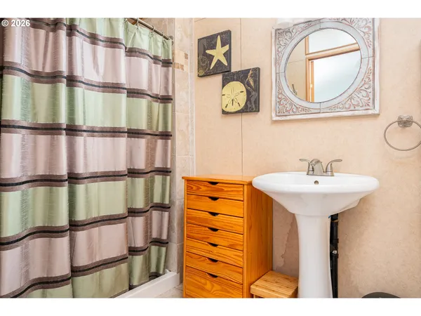 a bathroom with a sink a mirror and a painting on the wall