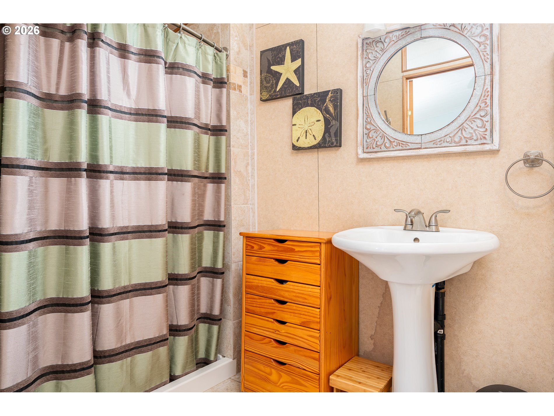648 South Easy Street Rockaway Beach, OR 97136 - Photo 16 of 35 a bathroom with a sink a mirror and a painting on the wall