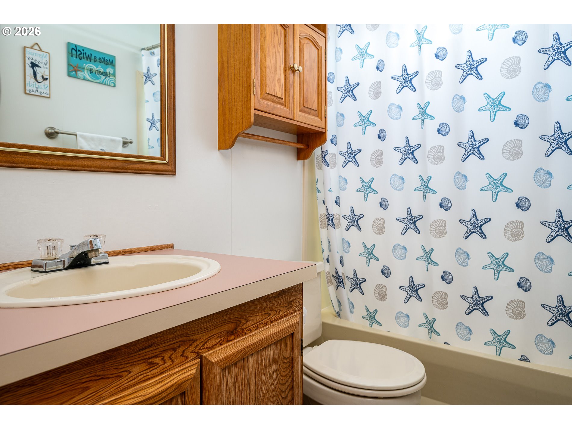 648 South Easy Street Rockaway Beach, OR 97136 - Photo 19 of 35 a bathroom with a sink a toilet and a mirror
