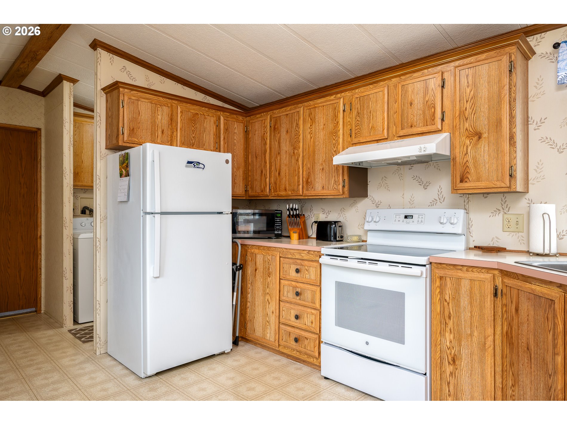 648 South Easy Street Rockaway Beach, OR 97136 - Photo 9 of 35 a kitchen with appliances a refrigerator and a sink