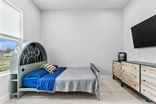 a bedroom with a bed and a flat screen tv