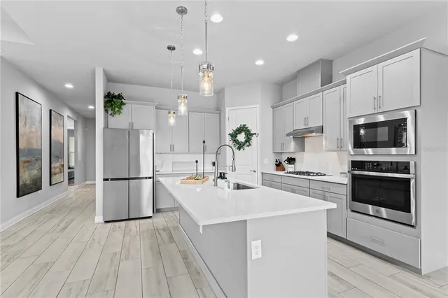 a kitchen with a sink a counter top space stainless steel appliances and cabinets