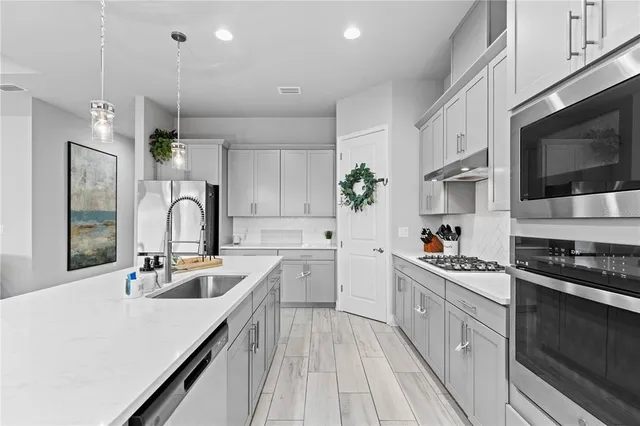 a kitchen with a sink stove top oven and cabinets
