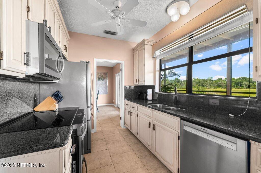 2010 Shadow Lane Neptune Beach, FL 32266 - Photo 10 of 61 a kitchen with stainless steel appliances granite countertop a sink and a large window