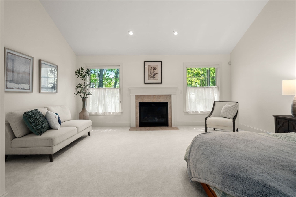 287 Langley Road, Unit 43 Newton, MA 02459 - Photo 25 of 36 a bedroom with furniture and a fireplace