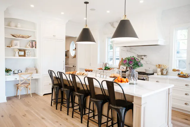 a dining room filled chandelier and wooden floor