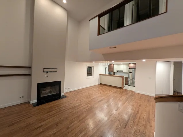a view of a hallway to a hallway with wooden floor and stairs