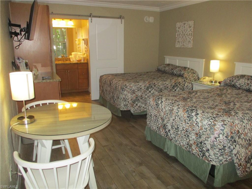 2555 9th Street North, Unit 131 Naples, FL 34103 - Photo 2 of 17 a bedroom with a bed and dresser