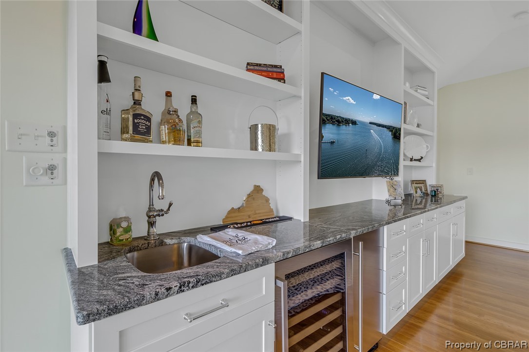 192 Bayberry Point Lane Kilmarnock, VA 22482 - Photo 29 of 49 Bar featuring built in features, light hardwood flooring, and dark countertops