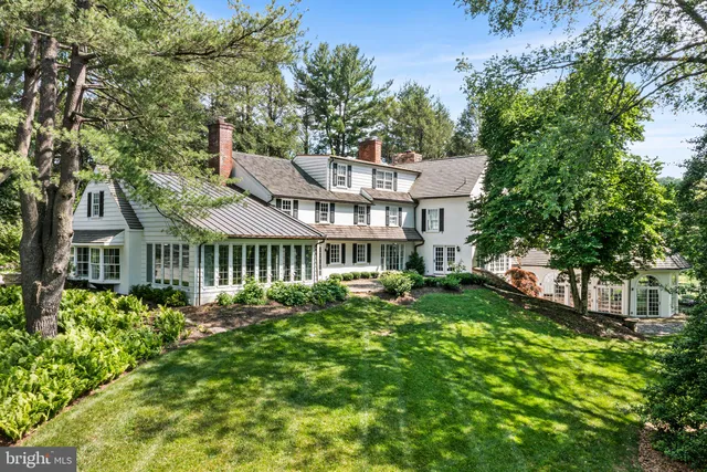 a front view of a house with a garden and trees