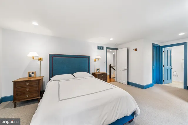 a spacious bedroom with a bed and a dresser