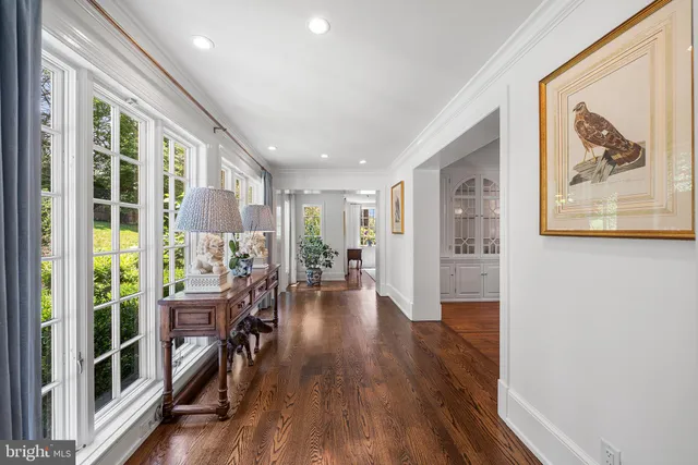 a view of a hallway with wooden floor and windows
