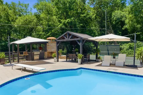 a view of a house with pool and chairs