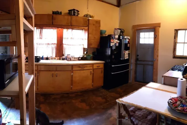 a kitchen that has a lot of cabinets a sink and a window