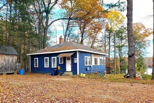 a view of a house with a yard and large tree