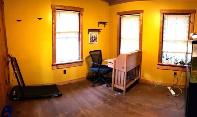 a room with couch wooden floor and a window