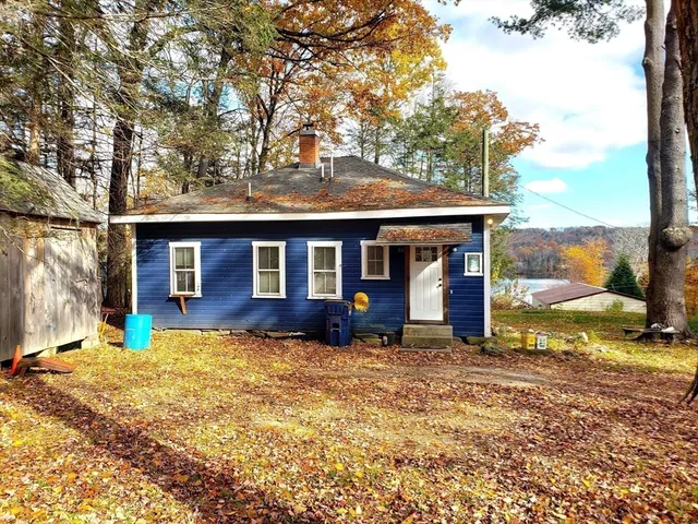 a view of a house with a large tree and a yard