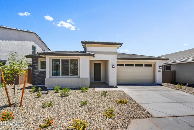 a front view of a house with a garden and plants
