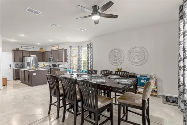 a dining room with a table chairs and a kitchen view