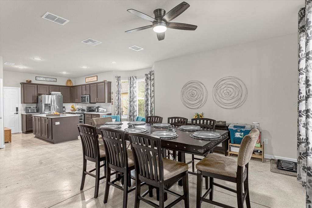 5781 Southwest 39th Street Ocala, FL 34474 - Photo 12 of 45 a dining room with a table chairs and a kitchen view
