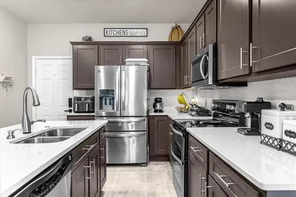 a kitchen with a sink a refrigerator and cabinets