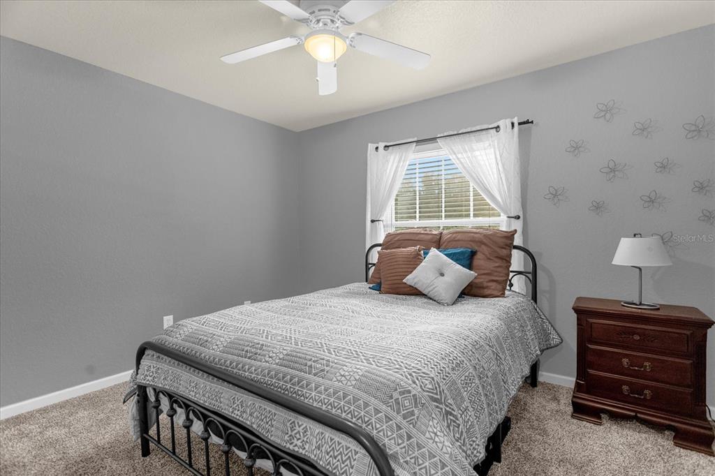 5781 Southwest 39th Street Ocala, FL 34474 - Photo 20 of 45 a bedroom with a bed and a chandelier