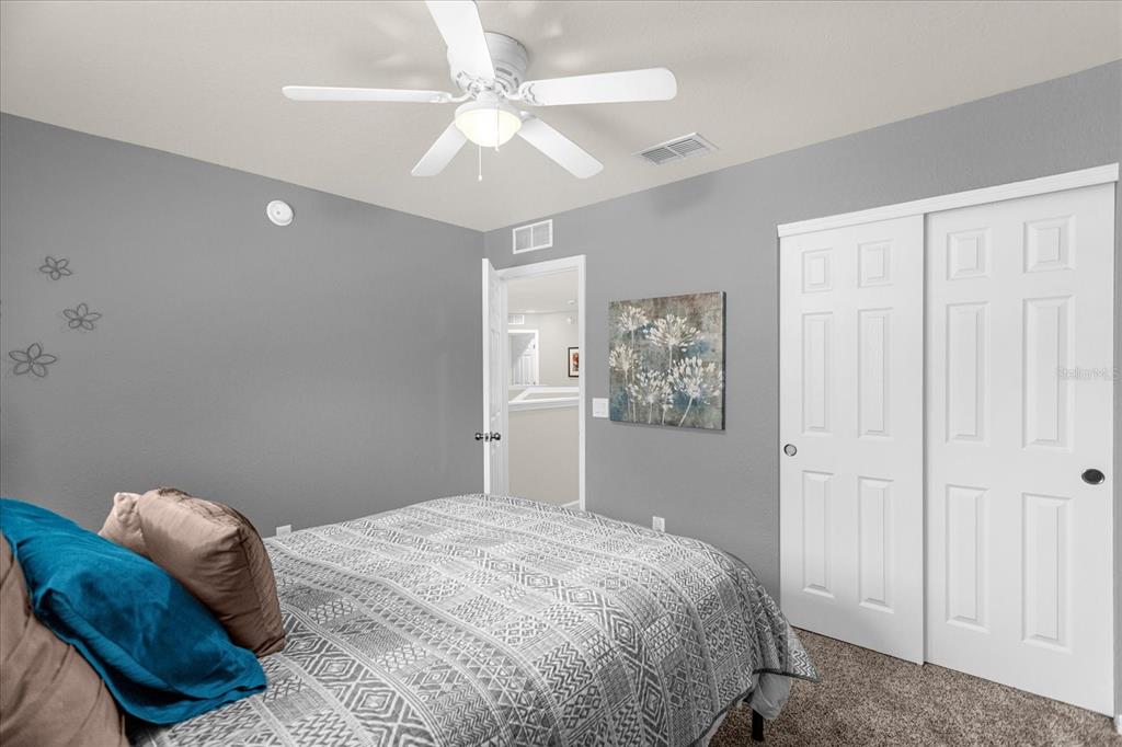 5781 Southwest 39th Street Ocala, FL 34474 - Photo 21 of 45 a bedroom with a large bed and a chandelier