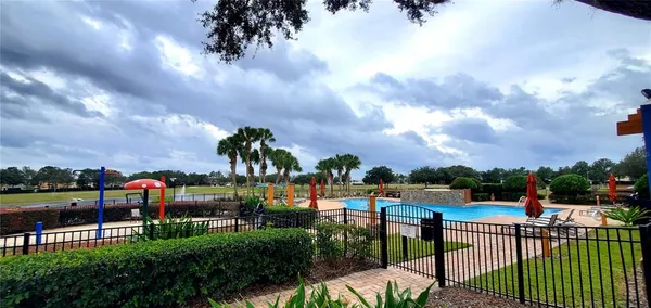 a view of a backyard with a fire pit and iron fence