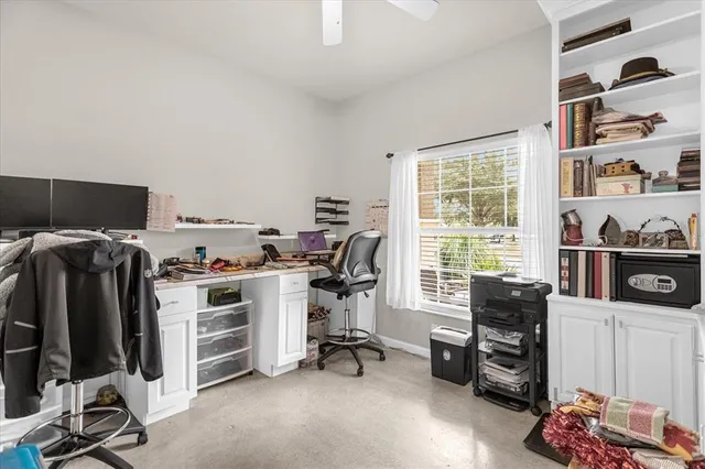 a view of a workspace with furniture and a window