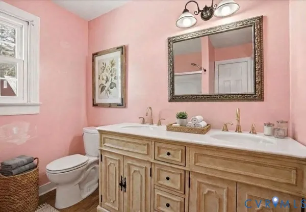 a bathroom with a granite countertop toilet sink and mirror