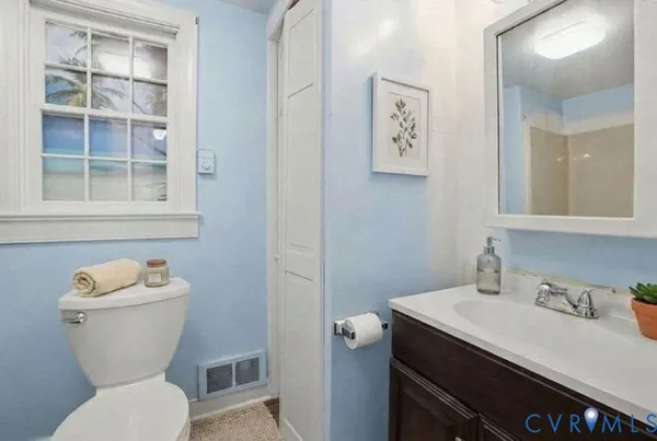 a bathroom with a toilet sink and mirror