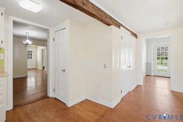 a view of a hallway with wooden floor and closet area