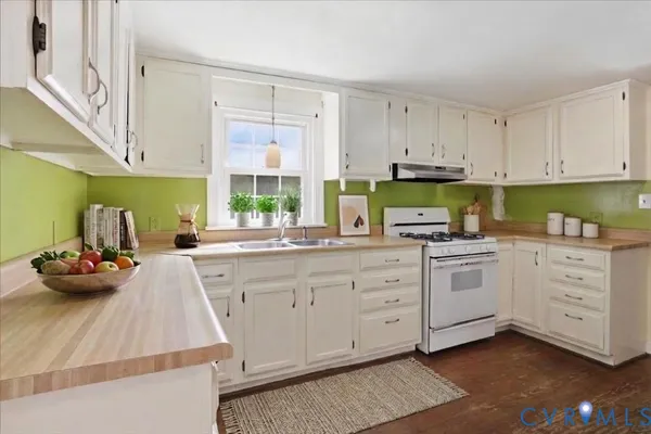 a kitchen with granite countertop a stove sink and cabinets